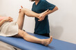 © ADDICTIVE STOCK - Physiotherapist evaluates leg mobility in a patient