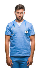 Canvas Print - Young handsome doctor nurse man over isolated background skeptic and nervous, frowning upset because of problem. Negative person.