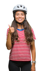 Canvas Print - Young arab cyclist woman wearing safety helmet over isolated background doing happy thumbs up gesture with hand. Approving expression looking at the camera with showing success.