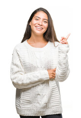 Canvas Print - Young beautiful arab woman wearing winter sweater over isolated background with a big smile on face, pointing with hand and finger to the side looking at the camera.