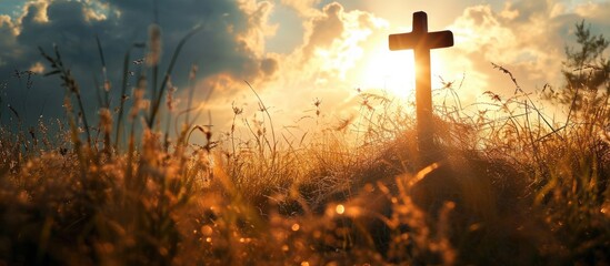 Wall Mural - A cross on top of grass facing the sun shining down on it