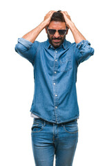 Wall Mural - Adult hispanic man wearing sunglasses over isolated background suffering from headache desperate and stressed because pain and migraine. Hands on head.