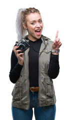 Poster - Young blonde woman taking pictures using vintage camera over isolated background surprised with an idea or question pointing finger with happy face, number one