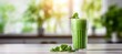 Green smoothie in a tall glass on the table with mint leaves. The concept of healthy eating and proper lifestyle. Еmpty space for text. Banner.

