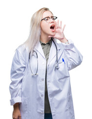 Canvas Print - Young blonde doctor woman over isolated background shouting and screaming loud to side with hand on mouth. Communication concept.