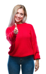 Poster - Young blonde woman wearing winter sweater over isolated background smiling friendly offering handshake as greeting and welcoming. Successful business.