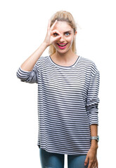 Sticker - Young beautiful blonde woman wearing stripes sweater over isolated background doing ok gesture with hand smiling, eye looking through fingers with happy face.