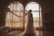Bride near the window. the bride in a wedding dress, stands back, you can see her silhouette, against the light, boudoir morning of the bride. wedding day. Selective focus.