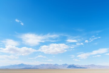 Wall Mural - A seamless expanse of blue sky, interrupted only by the silhouettes of distant mountains, Generative AI