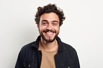 Portrait of a handsome young man with curly hair smiling at the camera