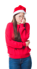 Wall Mural - Young Chinese woman over isolated background wearing christmas hat looking stressed and nervous with hands on mouth biting nails. Anxiety problem.