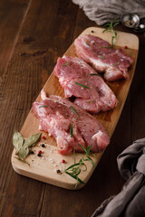 Wall Mural - a piece of fresh raw pork meat with spices on a brown wooden table. Meat with spices