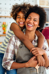 Wall Mural - African american woman hugging her smiling teen daughter. Family love single parent child concept