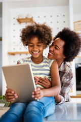 Wall Mural - Happy african american single mother helping child with distance education. Online education