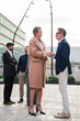 © Jose Calsina - Vertical. Handshake between businessman and corporate woman at workplace. Business people. Professional colleagues talking and greeting at startup meeting. Agreement or deal of two executive workers