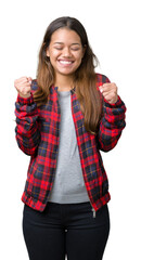 Sticker - Young beautiful brunette woman wearing a jacket over isolated background excited for success with arms raised celebrating victory smiling. Winner concept.