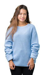 Wall Mural - Young beautiful brunette woman wearing blue winter sweater over isolated background Relaxed with serious expression on face. Simple and natural looking at the camera.