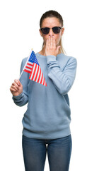 Poster - Beautiful young woman holding USA flag cover mouth with hand shocked with shame for mistake, expression of fear, scared in silence, secret concept