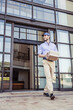 © Stefanie - Package delivery person picking up package at large office building.