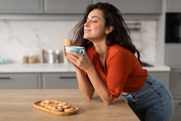 Wall Mural - Content young woman savoring coffee at home