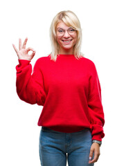 Poster - Young beautiful blonde woman wearing sweater and glasses over isolated background smiling positive doing ok sign with hand and fingers. Successful expression.