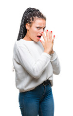 Wall Mural - Young braided hair african american girl wearing winter sweater over isolated background smelling something stinky and disgusting, intolerable smell, holding breath with fingers on nose. Bad smells.