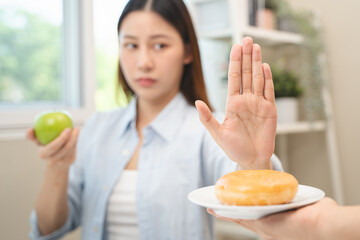 Canvas Print - Diet food loss weight concept, Hand of woman pushing sweet away and avoid to eat fried chicken to control cholesterol and sugar.