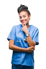 Poster - Young braided hair african american girl professional surgeon over isolated background looking confident at the camera with smile with crossed arms and hand raised on chin. Thinking positive.