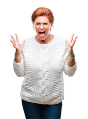 Poster - Atrractive senior caucasian redhead woman wearing winter sweater over isolated background celebrating mad and crazy for success with arms raised and closed eyes screaming excited. Winner concept