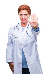 Canvas Print - Senior caucasian doctor woman wearing medical uniform over isolated background doing stop sing with palm of the hand. Warning expression with negative and serious gesture on the face.