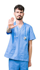 Wall Mural - Young handsome nurse man wearing surgeon uniform over isolated background doing stop sing with palm of the hand. Warning expression with negative and serious gesture on the face.