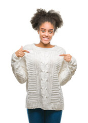 Sticker - Young afro american woman wearing winter sweater over isolated background looking confident with smile on face, pointing oneself with fingers proud and happy.