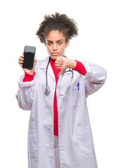 Sticker - Young afro american doctor woman using smartphone over isolated background with angry face, negative sign showing dislike with thumbs down, rejection concept