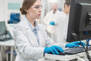 female scientist working in a modern equipped computer laboratory analyzes blood samples and genetic materials using special machines in a modern laboratory.