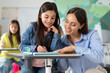 © Home-stock - Young teacher explaining something to preteen girl, studying, learning language with school children sitting in classroom