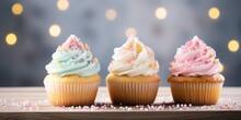 Cupcakes With Colorful Icing On Wooden Table And Bokeh Background