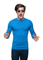 Wall Mural - Young man wearing funny thug life glasses over isolated background afraid and shocked with surprise expression, fear and excited face.