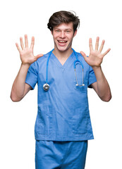 Wall Mural - Young doctor wearing medical uniform over isolated background showing and pointing up with fingers number ten while smiling confident and happy.