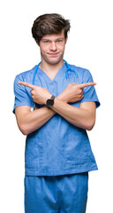 Wall Mural - Young doctor wearing medical uniform over isolated background Pointing to both sides with fingers, different direction disagree