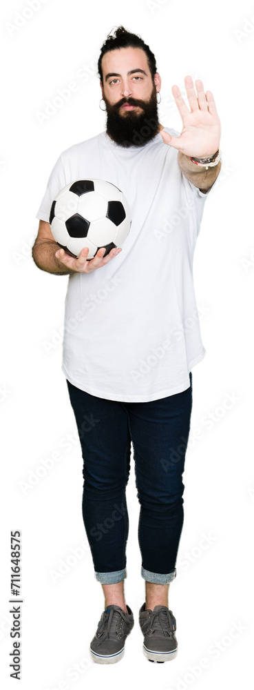 Young man with long hair and bear holding soccer football ball with ...