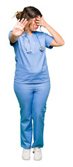 Poster - Young adult doctor woman wearing medical uniform covering eyes with hands and doing stop gesture with sad and fear expression. Embarrassed and negative concept.