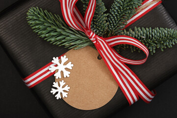 Wall Mural - Gift box with fir tree sprig and label on dark background. Closeup. Space for your text