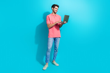 Aufkleber - Full body length photo of cheerful handsome young guy working at home remotely using laptop isolated on aquamarine color background