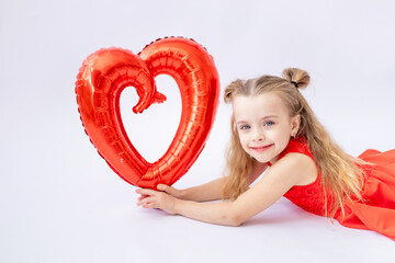 a cute little girl child in a red dress holds a large balloon in the shape of a heart on a white isolated background, the concept of Valentine's day, a place for text