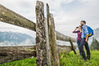 glückliches Paar in Karohemden  mit Fernglas an einer Alm in den Bergen, Österreich