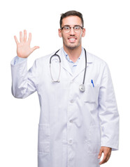 Canvas Print - Handsome young doctor man showing and pointing up with fingers number five while smiling confident and happy.