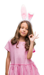 Sticker - Brunette hispanic girl wearing easter rabbit ears doing ok sign with fingers, excellent symbol