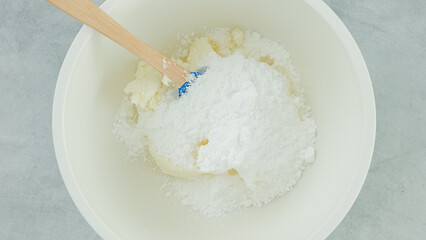 Cream cheese whipped cream recipe. Mixing cream cheese, sugar powder, and whipping cream together in a bowl. Close-up preparation process, recipe