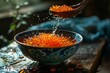 Red caviar in a ceramic bowl and in the spoon above it, atmospheric photo