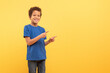 © Prostock-studio - Boy pointing sideways at free space on yellow background